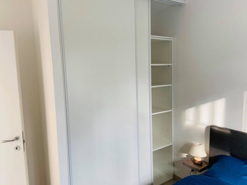 Camera da letto moderna con armadio bianco integrato e scaffalature presso la Résidence Marina di Bravone, Linguizzetta