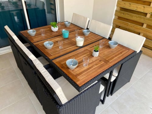 Tavolo da pranzo all'aperto a Marina di Bravone con piano in legno, sedie in rattan, coperto e vista mare a Linguizzetta