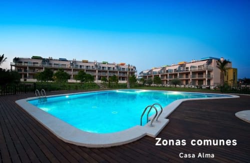 Piscine turquoise brillante au complexe résidentiel Casa Alma à Sant Jordi, bâtiments modernes sous un ciel dégagé