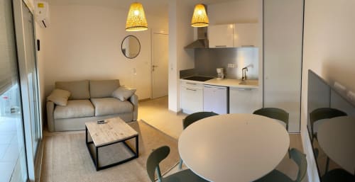 Modern T2 apartment at Résidence Marina di Bravone featuring dining area, living room with sofa, and equipped kitchen