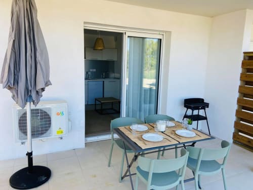 Modern beachfront apartment dining area at Marina di Bravone with terrace access, set table, and sea views