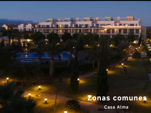 Complexe d'appartements Casa Alma au crépuscule avec piscine illuminée et jardins à Sant Jordi, Espagne