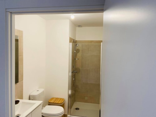Bagno moderno a Résidence Marina di Bravone, Linguizzetta con doccia, wc, lavabo e sgabello in legno