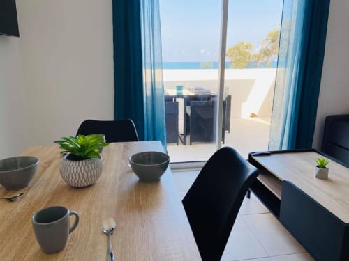 Accueillant T2 à la Résidence Marina di Bravone avec vue mer, table de salle à manger et terrasse en front de plage à Linguizzetta