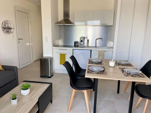 Appartement T2 moderne à la Résidence Marina di Bravone à Linguizzetta avec table à manger, cuisine et décoration contemporaine