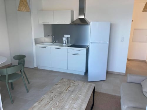 Modern kitchenette in beachfront apartment at Résidence Marina di Bravone, Linguizzetta, featuring white cabinetry and light