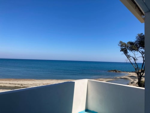 Vue sur la mer depuis l'appartement de la Résidence Marina di Bravone en Corse, avec une mer turquoise et une plage de sable fin