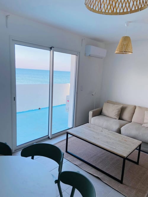 Appartement vue mer Marina di Bravone à Linguizzetta, canapé moderne, coin repas et accès direct à la terrasse