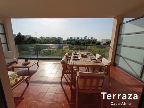Grande terrasse de l'appartement Casa Alma à Sant Jordi avec table à manger, salon et vue sur les immeubles résidentiels