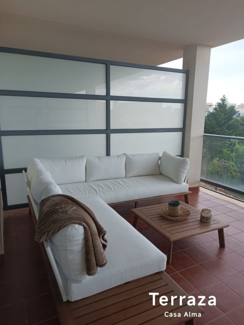 Terrasse moderne de Casa Alma avec canapé blanc, table en bois et vue sur la ville à Sant Jordi