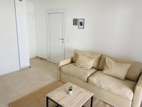 Studio moderne à la Résidence Marina di Bravone avec canapé beige, table basse et portes blanches à Linguizzetta