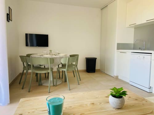 Appartement moderne en front de mer à la Résidence Marina di Bravone avec salle à manger, kitchenette et TV murale