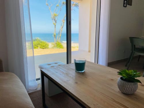 Appartement en front de mer à la Résidence Marina di Bravone avec vue sur la mer, bureau en bois, plante en pot et verre d'eau