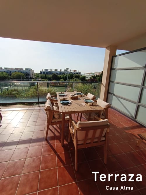 Terrasse de Casa Alma avec table à manger, vue sur la piscine et immeubles résidentiels à Sant Jordi
