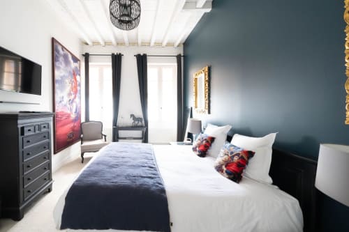 Chambre Melchior au Pavillon Des Millésimes à Lussac avec mur d'accent bleu, lit king-size, TV écran plat et vue sur la ville