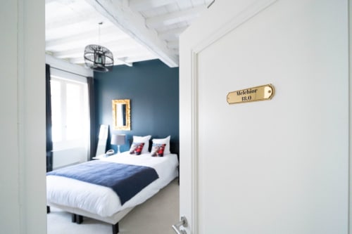 Entrée de la chambre Melchior au Pavillon Des Millésimes, hôtel Lussac avec chambre bleue et lit blanc visible
