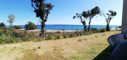 Terrazza fronte mare della Résidence Marina di Bravone, Linguizzetta, con spiaggia sabbiosa, vista sul mare e vegetazione mediterranea