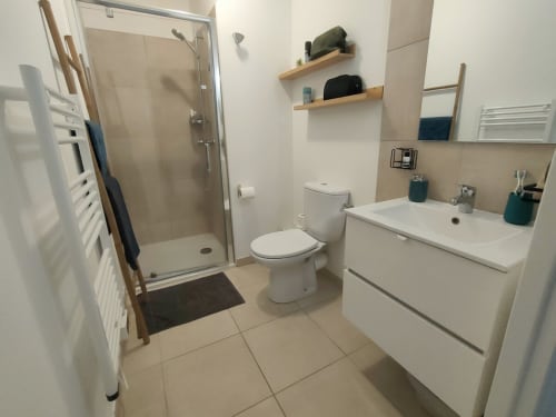 Bagno moderno della Résidence Marina di Bravone, Linguizzetta con lavabo bianco, wc e doccia walk-in