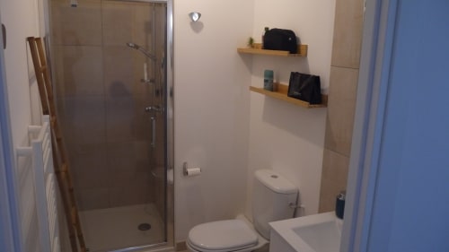 Moderno bagno in appartamento fronte mare di Résidence Marina di Bravone, Corsica, con doccia in vetro, toilette, lavandino e