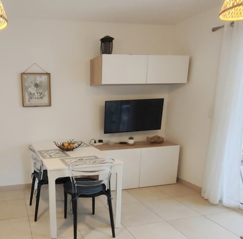 Cucina e zona pranzo moderna a Marina di Bravone, Linguizzetta con arredamenti bianchi e TV a schermo piatto