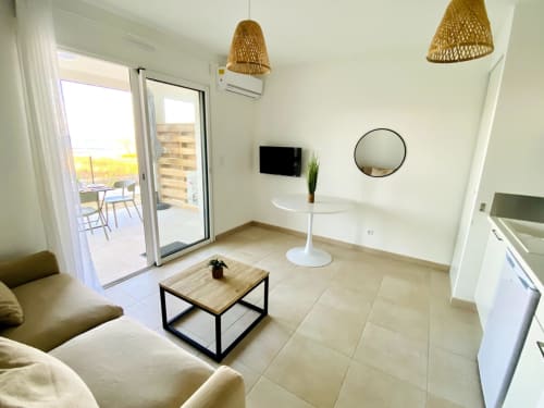 Salon moderne d'un appartement en bord de mer avec balcon à la Résidence Marina di Bravone, Linguizzetta