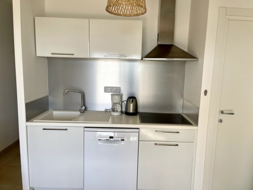 Cucina moderna nella Camera 87 di Résidence Marina di Bravone, Linguizzetta, con mobili bianchi e rivestimento in acciaio inox