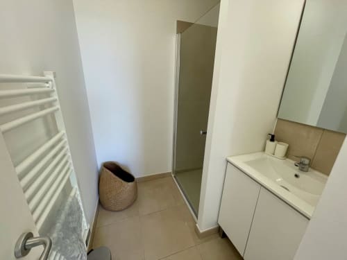 Bagno moderno alla Résidence Marina di Bravone con lavabo bianco, portasciugamani e box doccia a Linguizzetta