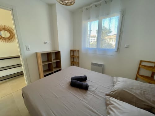 Chambre lumineuse à la Résidence Marina di Bravone à Linguizzetta avec lit double, étagères de rangement et fenêtres avec vue sur mer