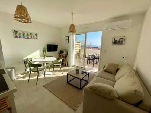 Appartement moderne à la Résidence Marina di Bravone avec canapé, table à manger et balcon vue mer à Linguizzetta