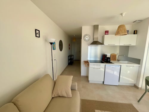 Studio moderne à la Résidence Marina di Bravone avec canapé beige, cuisine compacte et décoration neutre à Linguizzetta