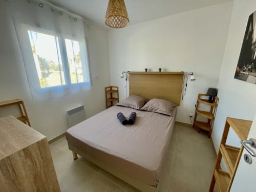 Chambre moderne à Marina di Bravone, Linguizzetta avec lit en bois, lumière naturelle et décoration minimaliste