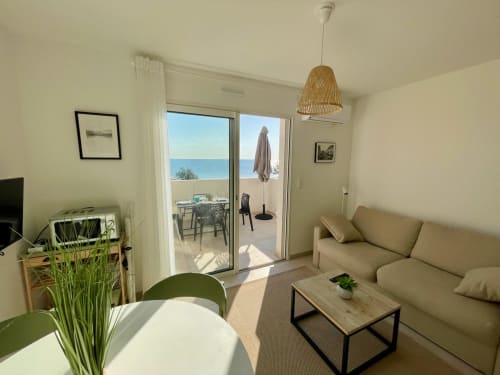 Lumineux appartement vue mer à Marina di Bravone, canapé beige, décor moderne et accès balcon océan