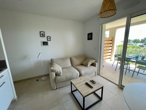 Séjour moderne à Marina di Bravone avec canapé beige, table basse et accès à la terrasse à Linguizzetta
