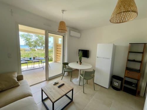 Appartement T3 moderne à la Résidence Marina di Bravone avec vue mer, kitchenette, coin repas et accès direct à la plage