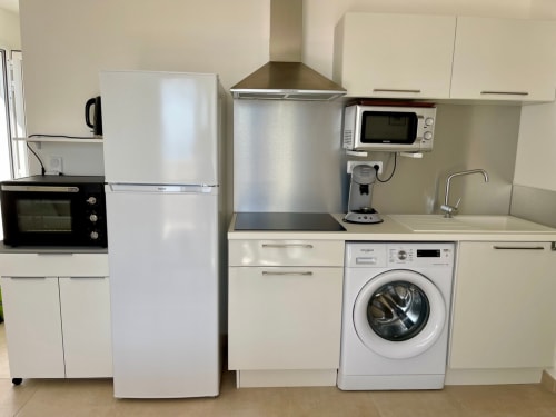 Modern kitchen in Marina di Bravone apartment with refrigerator, stove, microwave, washing machine and cooking essentials