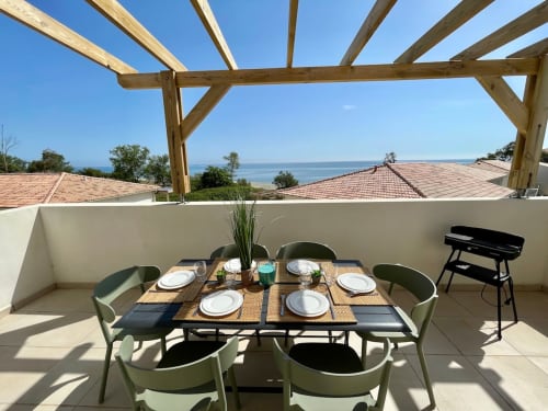 Marina di Bravone seaside terrace with dining table, wooden pergola, and sea views in Linguizzetta