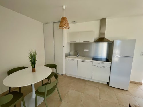 Modern kitchen and dining area in T3 apartment at Résidence Marina di Bravone, Linguizzetta with white cabinets, stainless
