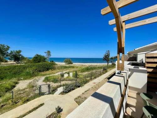 Marina di Bravone beachfront apartment with wooden pergola, direct beach access, and Mediterranean Sea view