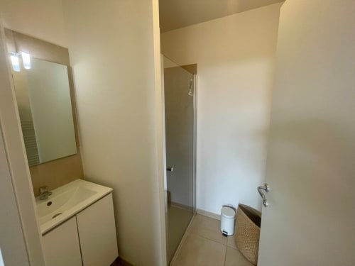 Salle de bain moderne à la Résidence Marina di Bravone avec lavabo, miroir, cabine de douche et carrelage