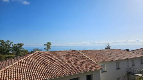 Toits d'appartements en front de mer aux tuiles terracotta donnant sur la Méditerranée, Résidence Marina di Bravone, Corse