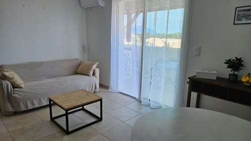 Lumineux appartement en front de mer à la Résidence Marina di Bravone avec vue sur la mer, canapé, table basse et portes coulissantes en verre