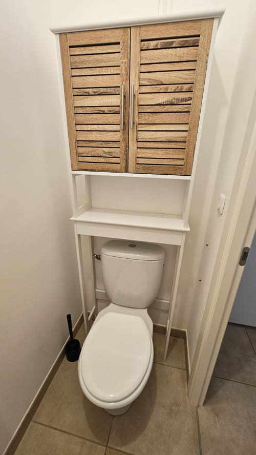 Salle de bain moderne avec rangement bois au-dessus des toilettes en céramique blanc, Résidence Marina di Bravone