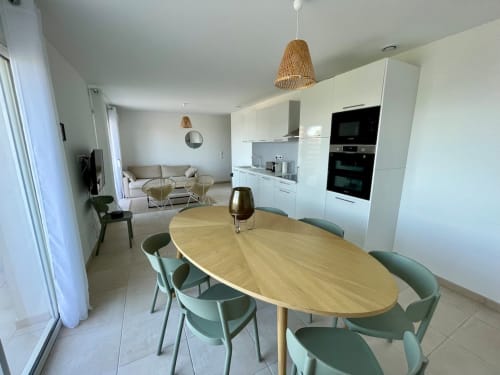 Modern open-plan apartment at Résidence Marina di Bravone with dining area, kitchen, and lounge space
