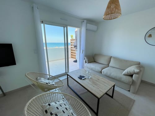 Beachfront apartment living room at Marina di Bravone with sea views, modern furniture and terrace access