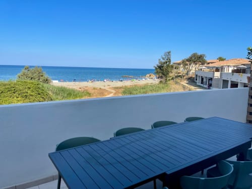 Waterfront terrace at Résidence Marina di Bravone with sea view, dining table, and beach access in Linguizzetta
