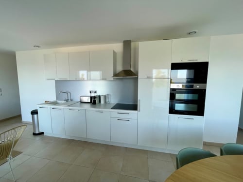 Modern white kitchen with stainless steel appliances at Résidence Marina di Bravone, Linguizzetta