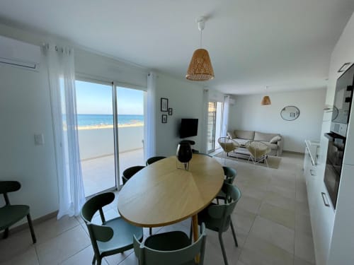 Waterfront apartment at Marina di Bravone with modern dining, kitchen, and sea views from the balcony
