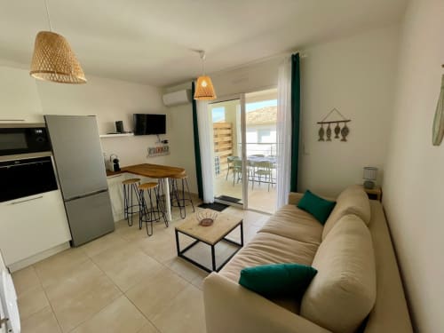Modern apartment at Résidence Marina di Bravone in Linguizzetta with open-plan living, beige sofa, kitchen, and balcony views