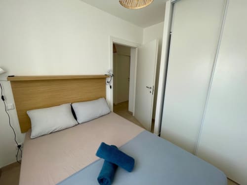 Modern bedroom at Résidence Marina di Bravone, Linguizzetta, with wooden headboard and white walls