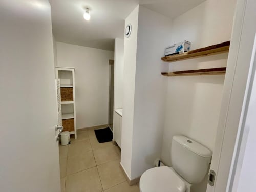 Bathroom at Résidence Marina di Bravone in Linguizzetta with toilet, wooden shelves, and tiled flooring